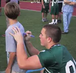 A young fan adds to the autograph collection on his T-shirt Saturday during Fan Day festivities on the Tulane campus.