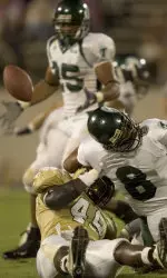 Lester Ricard pitches out to running back Matt Forte as Central Florida defensive back Jason Venson grabs Ricard's face mask.