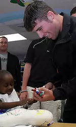 Junior outfielder Rustin Rebowe signs a t-shirt for a patient at the Pitt County Memorial Hospital as part of Thursday's C-USA Baseball Tournament Community Outreach Program.