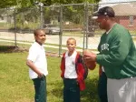 Defensive backs coach Jason Rollins instructs MLK, Jr. School students on a drill during the football clinic Tuesday.