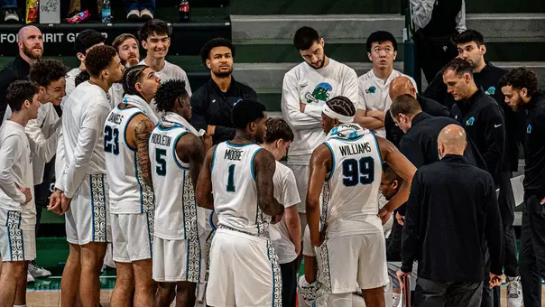 Tulane men's basketball in a team huddle during the Green Wave's game against Rice.