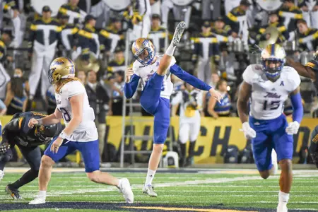 Thomas Bennett punting the football team