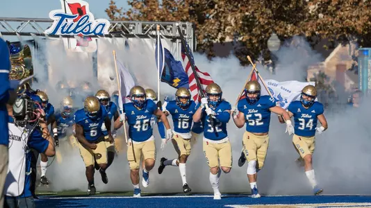 Players with military flags lead team run-out