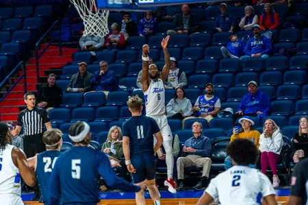 Romad Dean shoots a three against Manhattan Christian