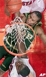 UAB's LeAndrew Bass, center, puts up a basket under pressure from Fresno State defenders in the first half