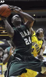 UAB guard Elijah Millsap (24) gets his shot blocked by Southern Mississippi forward Gary Flowers (4) in the first half of an NCAA college basketball game in Hattiesburg, Miss., Wednesday, Feb. 17, 2010. (AP Photo/Steve Coleman)