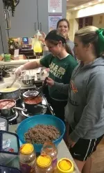 Members of the UAB softball team prepare a meal Tuesday night for members of the Ronald McDonald House.