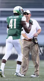 Coach Bill Clark congratulates Williams after his pick-six against North Texas.