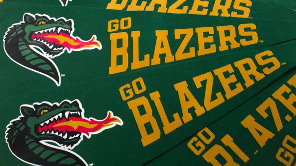 Close-up, stack fanned stack of UAB pennants with a dragon head that read "Go Blazers", 2018.