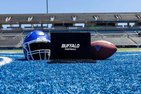 Laptop computer between a football helmet and football