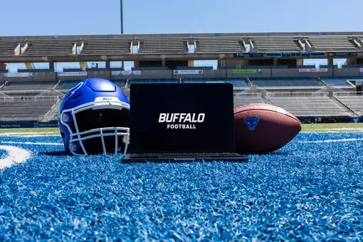 Laptop computer between a football helmet and football