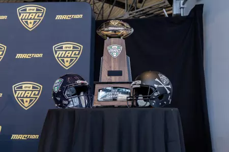 football helmets placed next to MAC Championship trophy