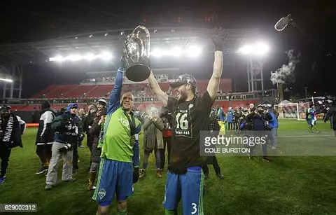 Seattle Sounders midfielder Osvaldo Alonso (6) and Seattle Sounders forward Brad Evans (3) celebrate with the MLS cup after their victory over Toronto FC at BMO Field on December 10, 2016 in Toronto. / AFP / Cole Burston (Photo credit should read COLE BURSTON/AFP via Getty Images)