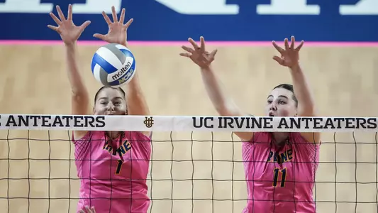 Nicole Feliciano and Taylor Boice go up for a double block in an NCAA women's volleyball match.