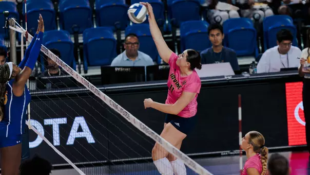 Taylor Boice makes contact with the ball above the net on a kill attempt in an NCAA women's volleyball match.