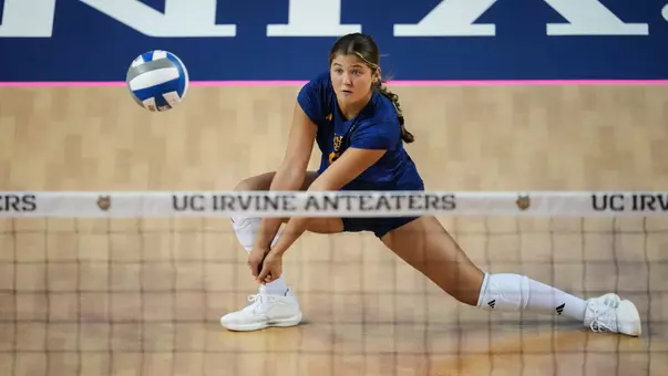 Whitney Wallace digs the ball in an NCAA women's volleyball match.
