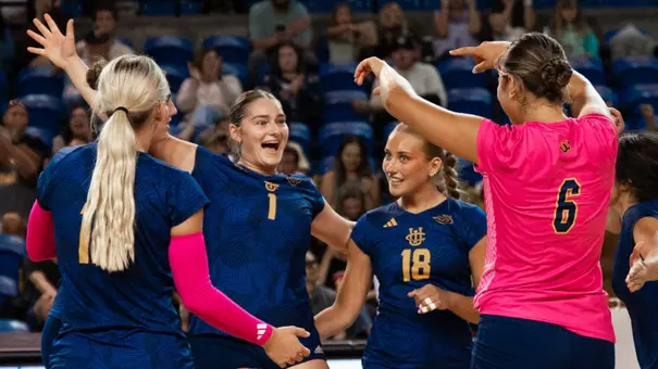 Nicole Feliciano celebrates a point with her teammates in an NCAA women's volleyball match.