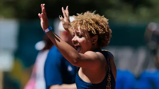 Joy Anderson with arms raised in celebration
