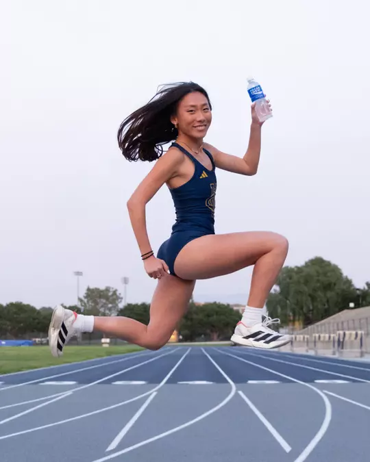 Anna Vogtmann poses with a Pocari Sweat bottle at Anteater Stadium