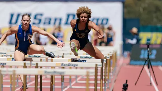 Joy Anderson going over a hurdle