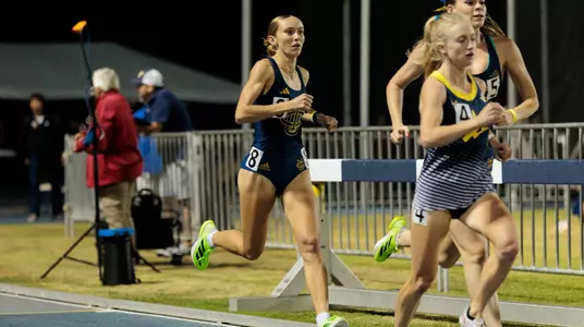 Kaia Schmidt in stride behind two other runners in a 1500-meter race