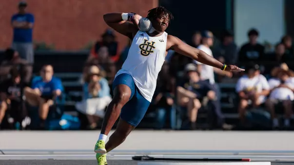 Chimobi Onye throws the shot put in front of a crowd at Jack Rose Track