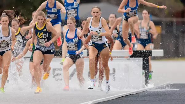 Kaia Schmidt leads the field at the water barrier in the steeplechase