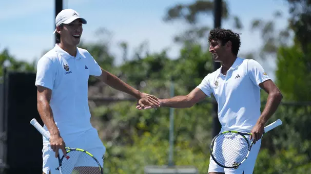 Max Faradnesh and Rohan Sachdev high five on the tennis court after a point