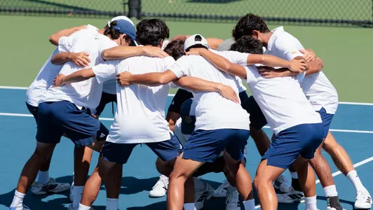 UC Irvine men's tennis huddle on court before a match