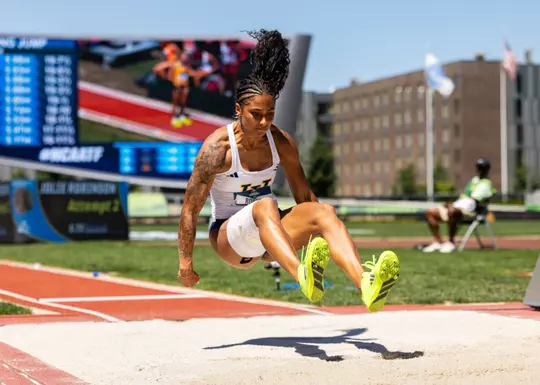 Photo of Jolie Robinson over the sand pit on a long jump attempt at the NCAA Championships