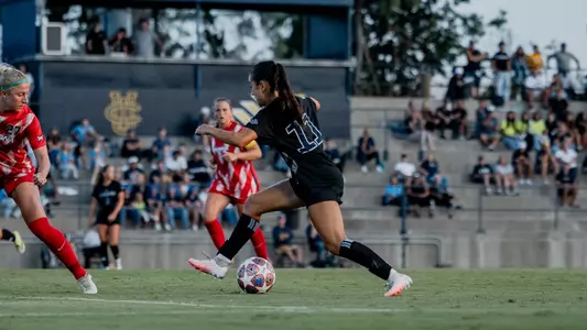 Oona Hartman dribbles through the Arizona defense in an exhibition in Anteater Stadium