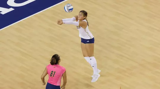Whitney Wallace digs the ball during an NCAA women's volleyball match.