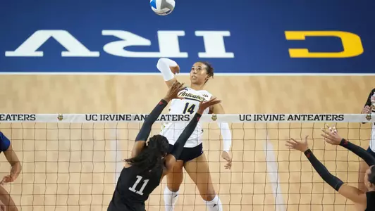 Brianna Brewer jumps at the net to hit the ball over the block in an NCAA women's volleyball match against LMU.