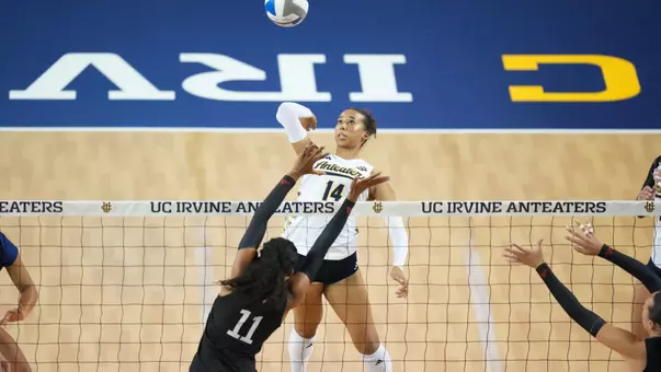 Brianna Brewer jumps at the net to hit the ball over the block in an NCAA women's volleyball match against LMU.