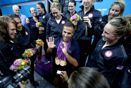 United States coach Adam Krikorian is draped in 13 of his team's gold medals aft