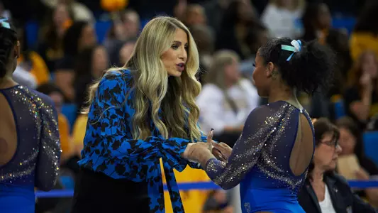 Autumn Grable encourages Jordan Chiles before her beam routine