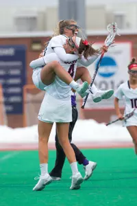 Seniors Carly Palmucci and Kate Finkelston celebrate after one of Finkelston's four goals in 12-10 victory over JMU.