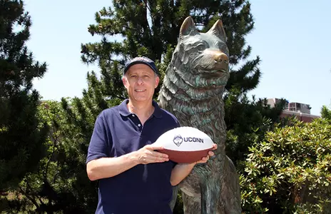 Bruce Banks ’77 (BUS) ’82 in front of the Husky statue on the Storrs Campus.