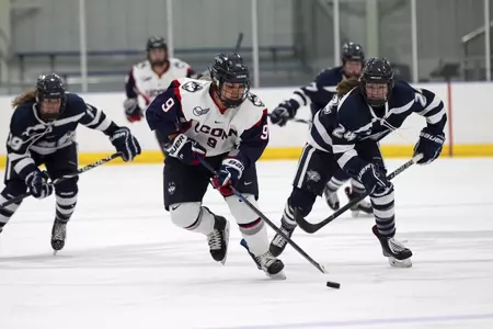 Natalie Snodgrass skates by UNH players