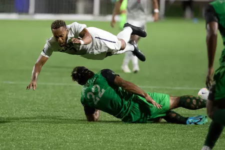Ahdan Tait dives over a player in a game against Manhattan College