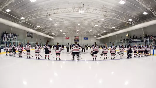 The Women's Ice Hockey team standing for the National Anthem