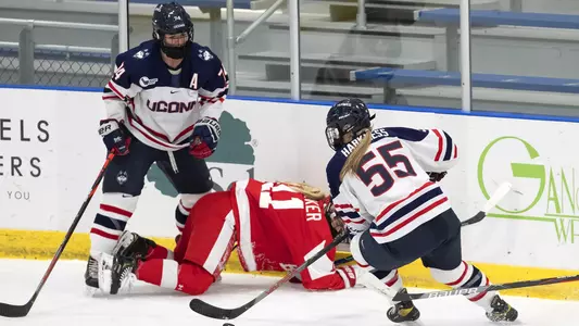 Emily Reid and Viki Harkness dig the put out of the corner against BU on December 11, 2020.
