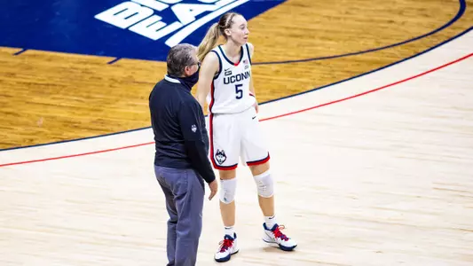 Paige Bueckers and head coach Geno Auriemma chat during the game against UML on December 12, 2020.