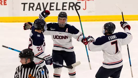 Carter Turnbull celebrates with Jonny Evans and Hudson Schandor after Turnbull's second goal of the season against UMass Lowell on December 21, 2020.