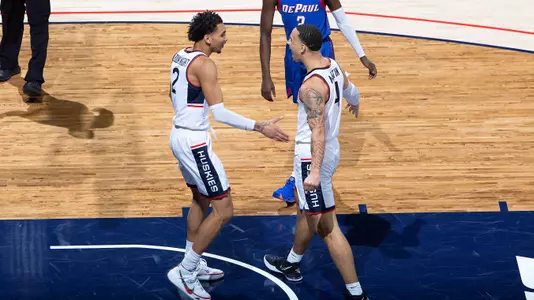 James Bouknight celebrates with Tyrese Martin against DePaul on December 30, 2020.