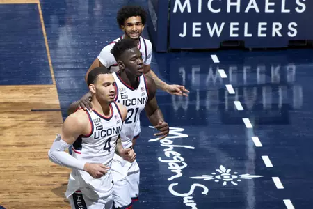 Adama Sanogo, Jalen Gaffney and Tyrese Martin run off the court for half time in the game against Butler on January 26th at Gampel Pavilion