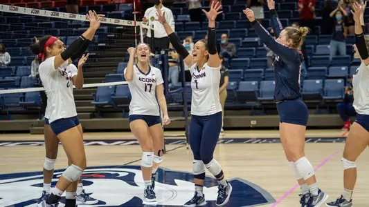 The volleyball team celebrating after defeating Providence