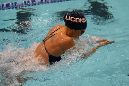 UConn swimmer takes a breath during their race