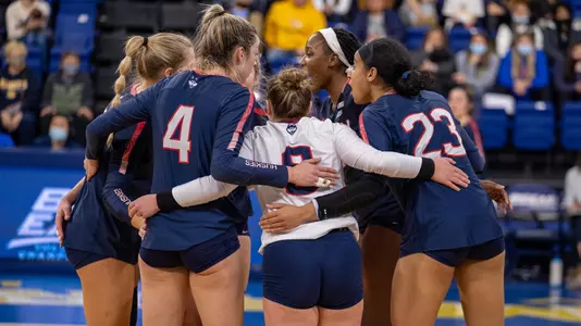 The volleyball team in a huddle at the BIG EAST Championship