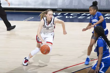 Paige bueckers dribbles past two defenders in the game against Seton hall at gampel pavilion on February 10th